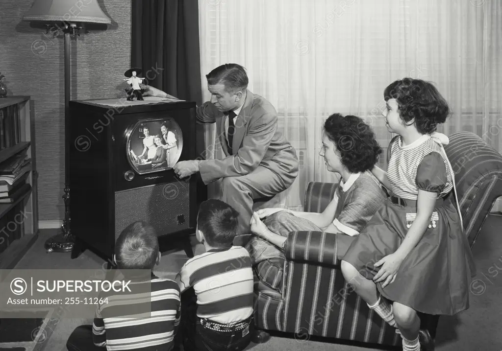 Vintage Photograph. Family sitting in living room watching television. Frame 1