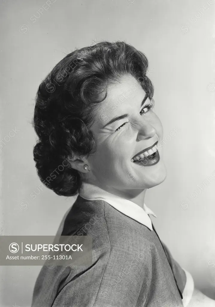 Vintage Photograph. Portrait of young woman winking.