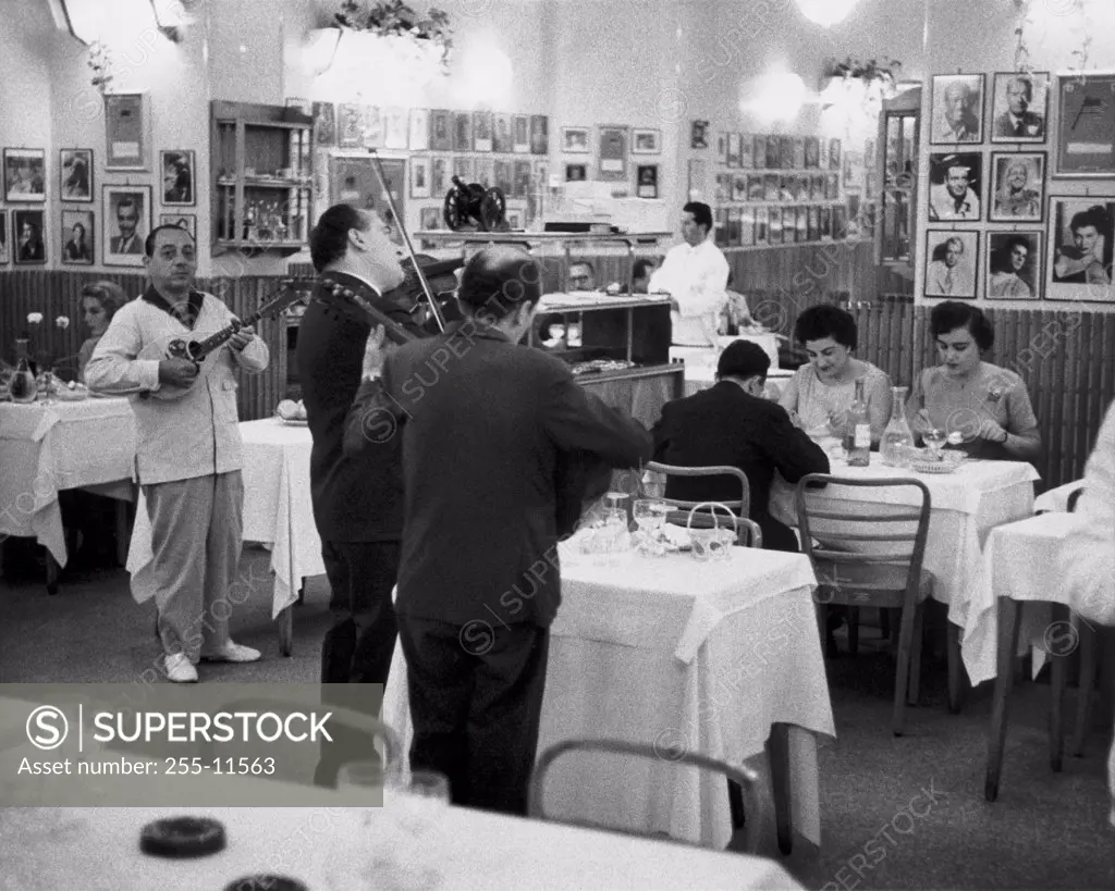 Musicians playing music instruments in a restaurant, Via Veneto, Rome, Italy