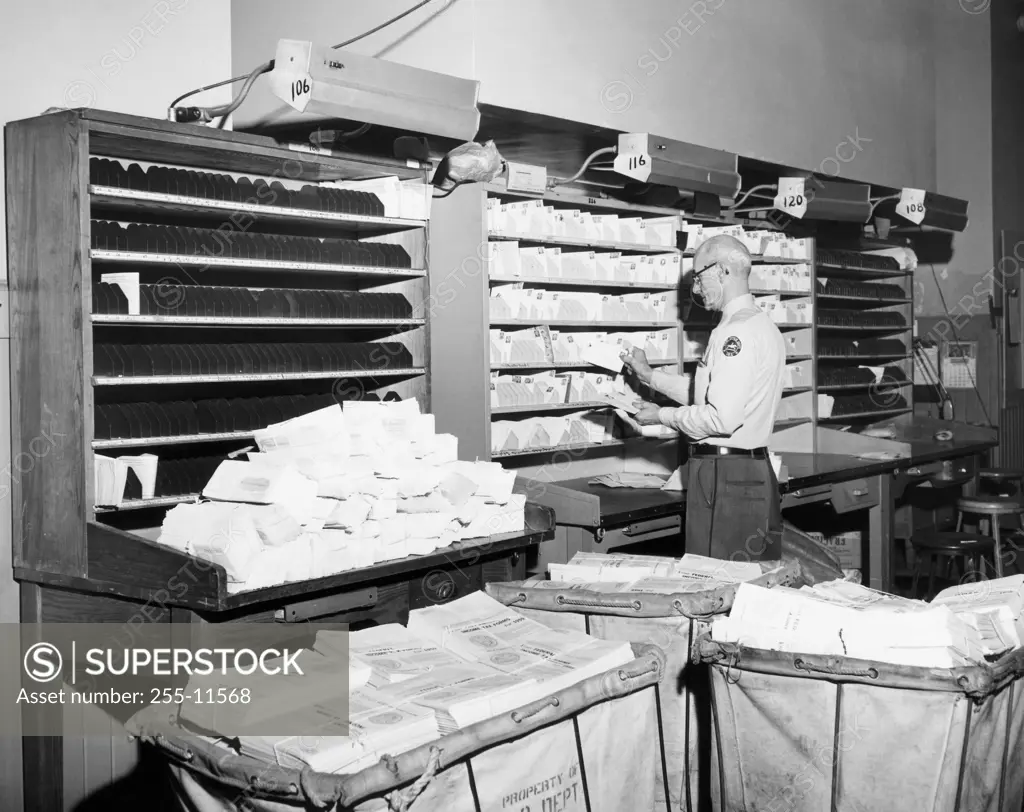 Postal worker sorting mail in a post office, USA