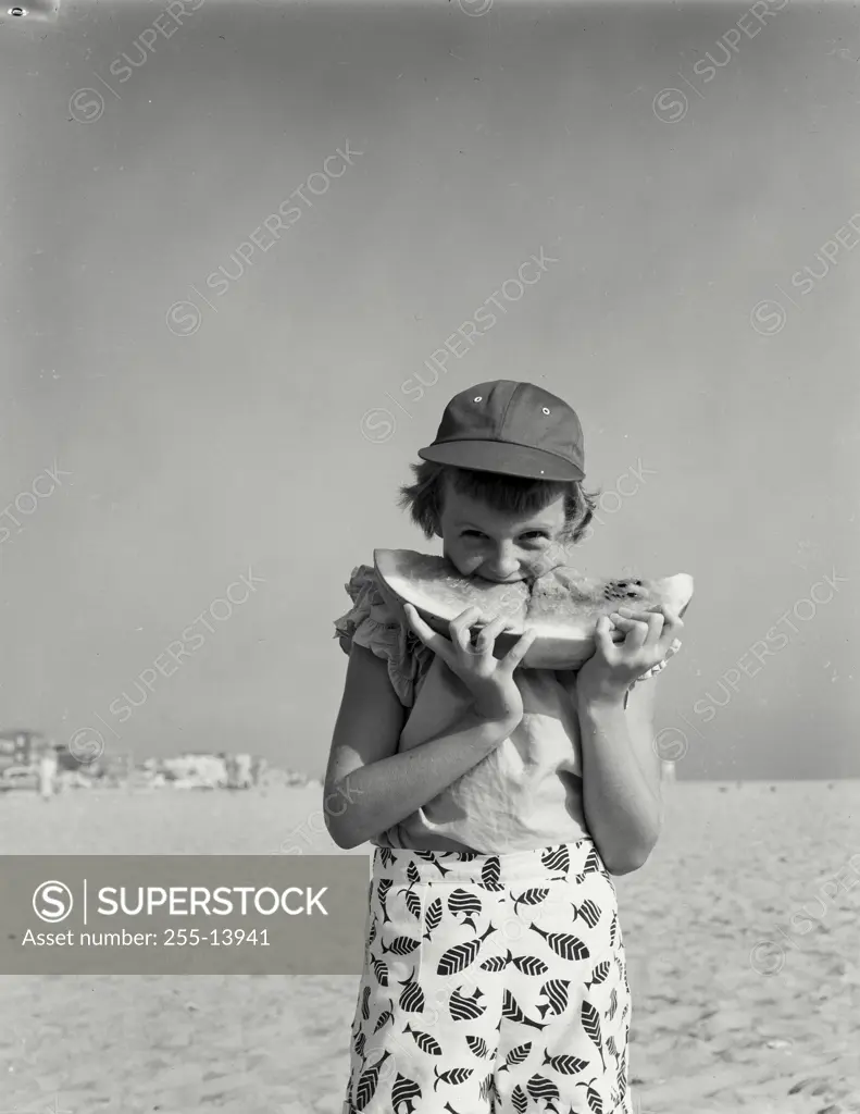 Vintage Photograph. Girl eating watermelon outside at the beach