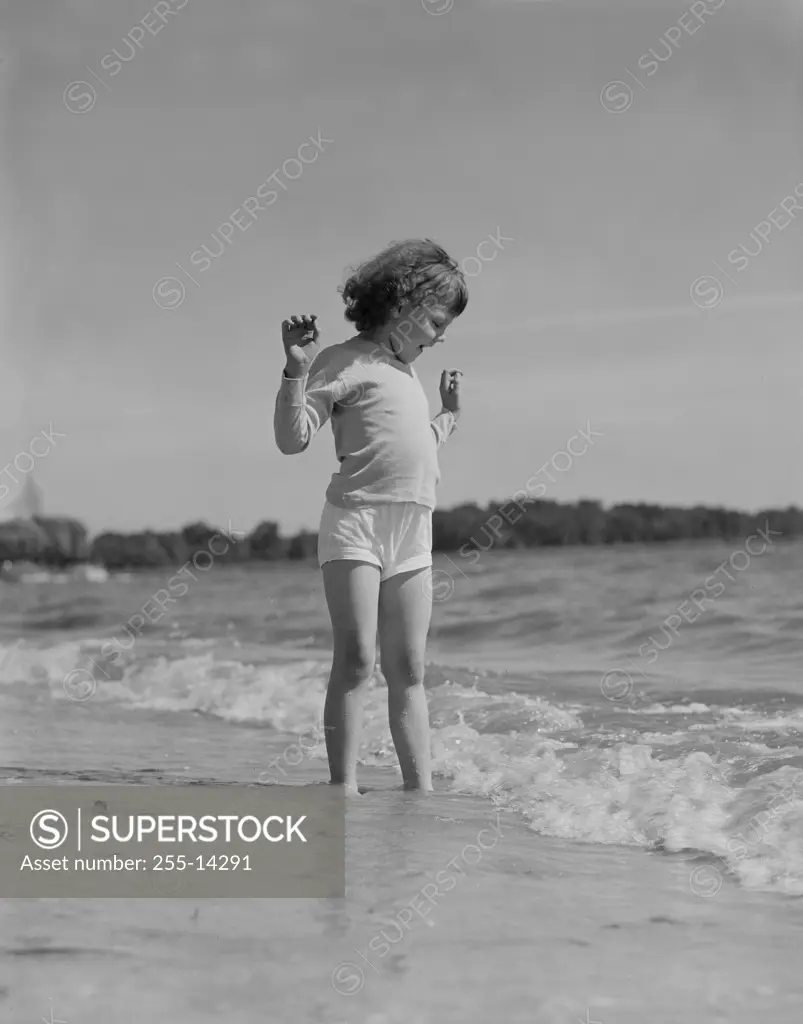 Girl standing in surf on beach