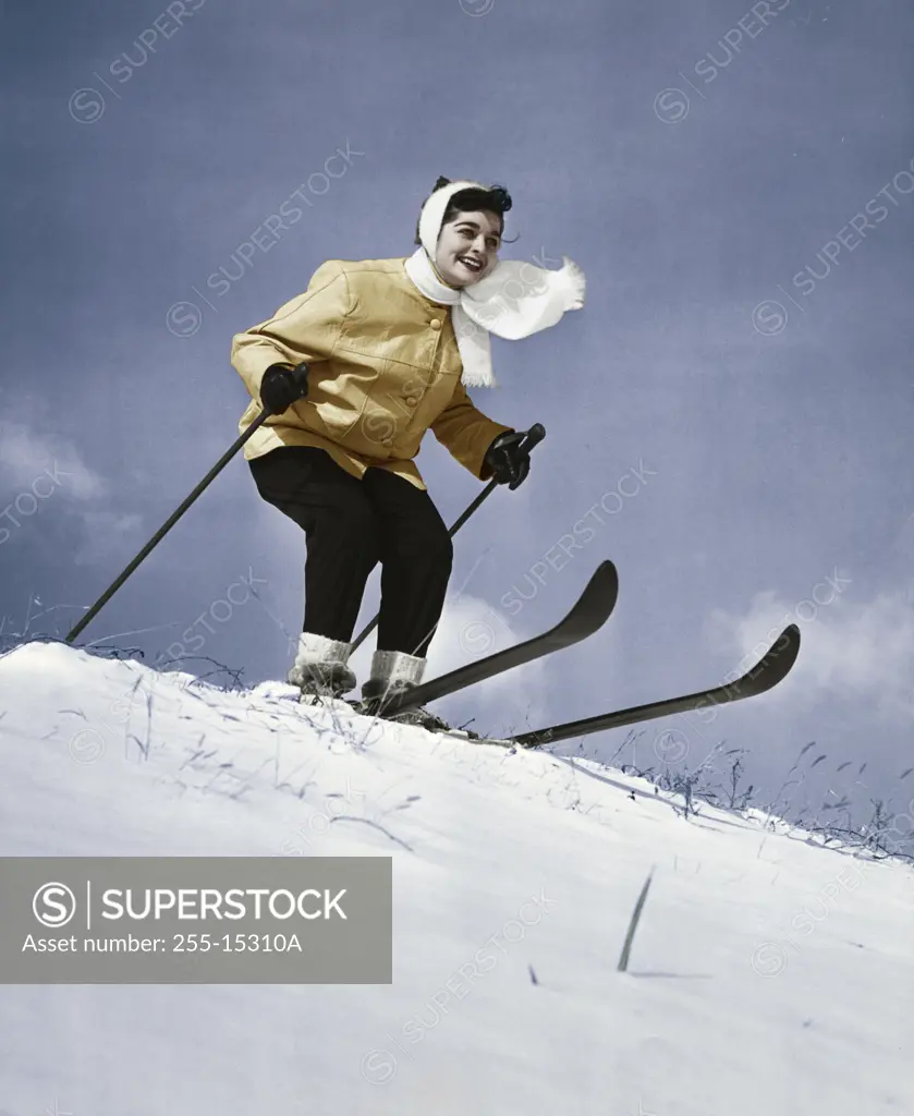 Low angle view of young woman skiing downhill