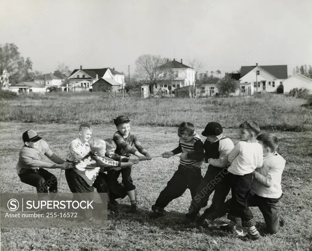 Boys pulling rope on field