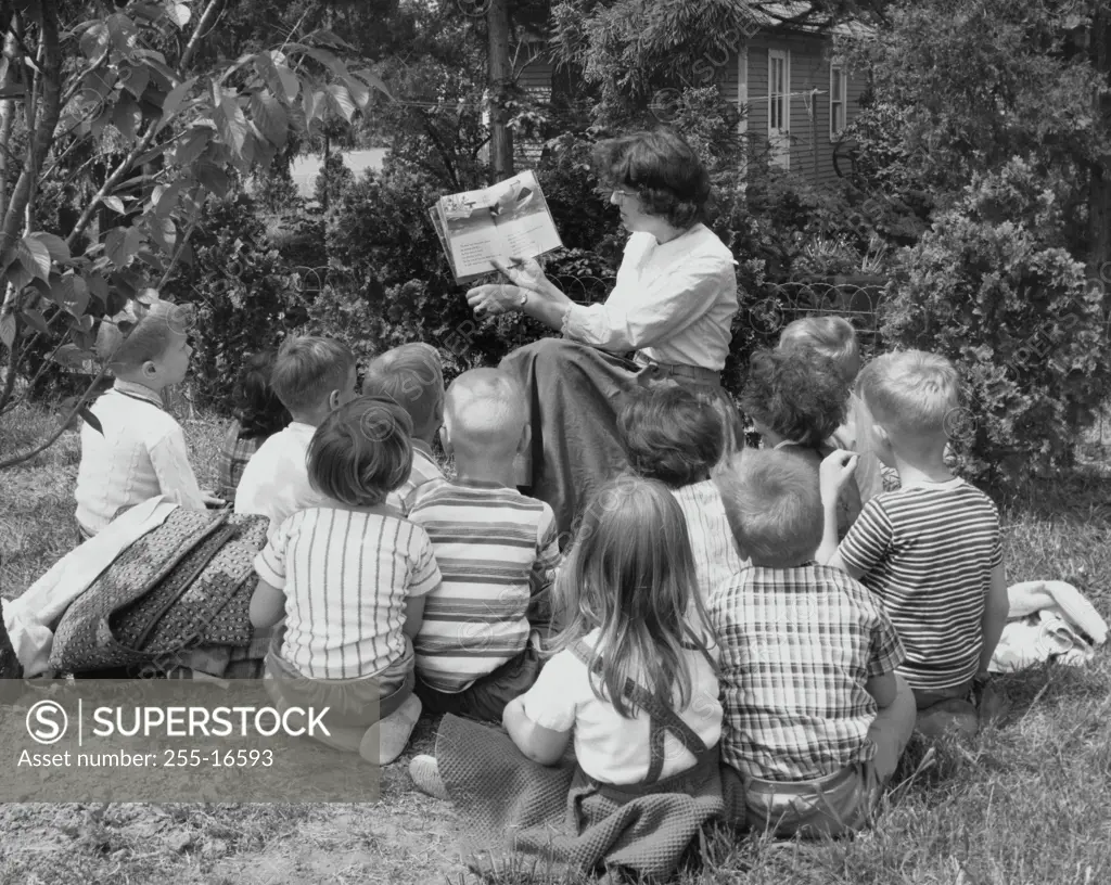 Female teacher teaching her students in a park