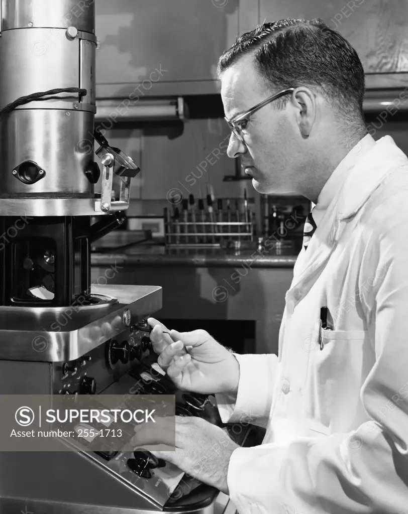 Side profile of a scientist working on an electron microscope