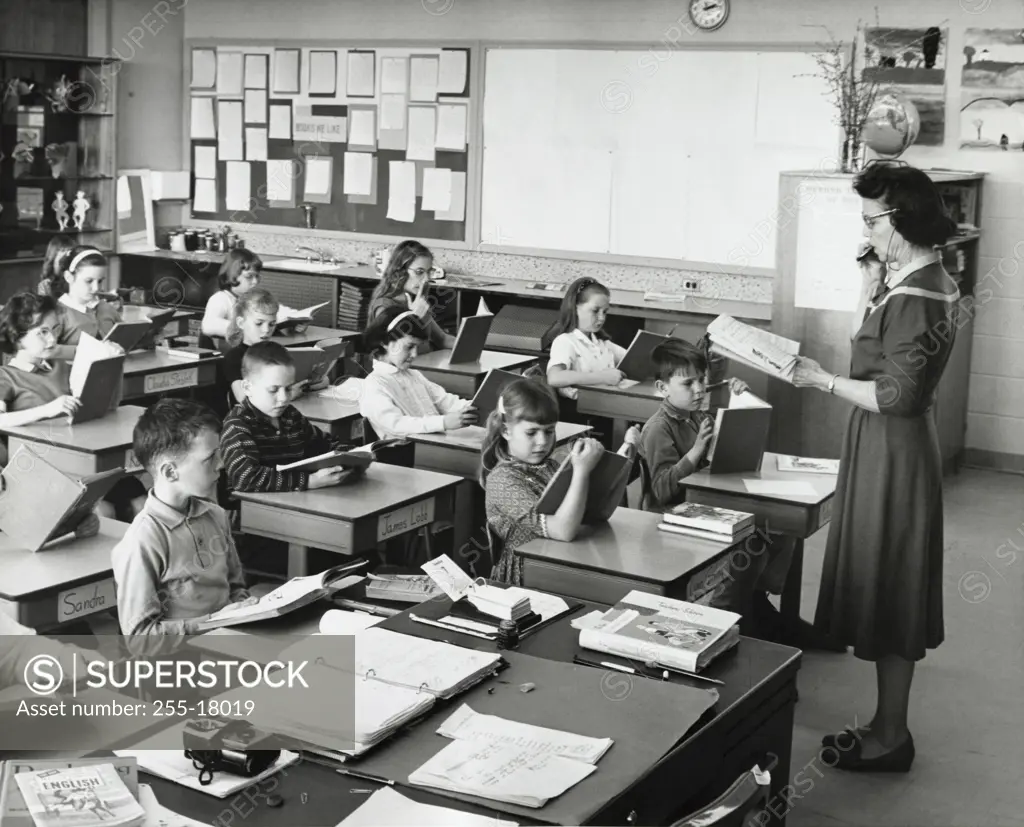 School children in a classroom with a female teacher