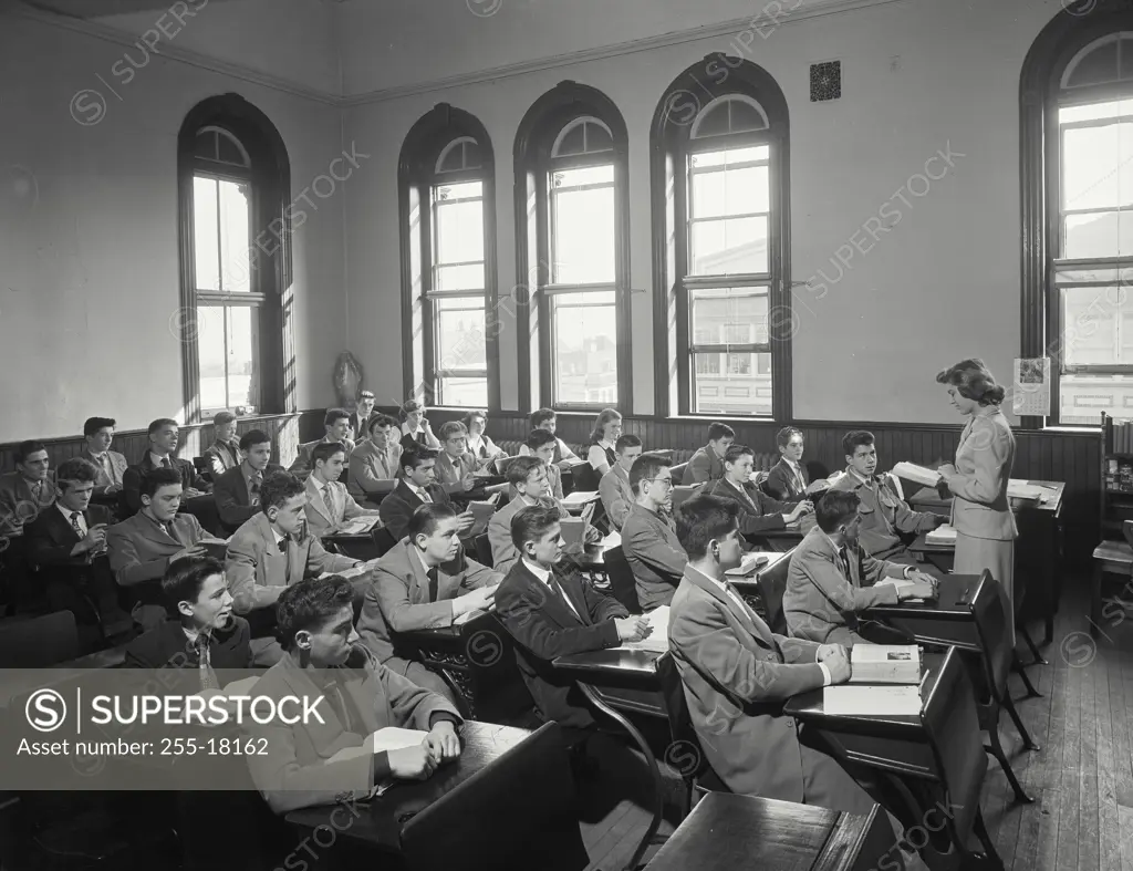 Vintage photograph. Female teacher teaching students in a classroom