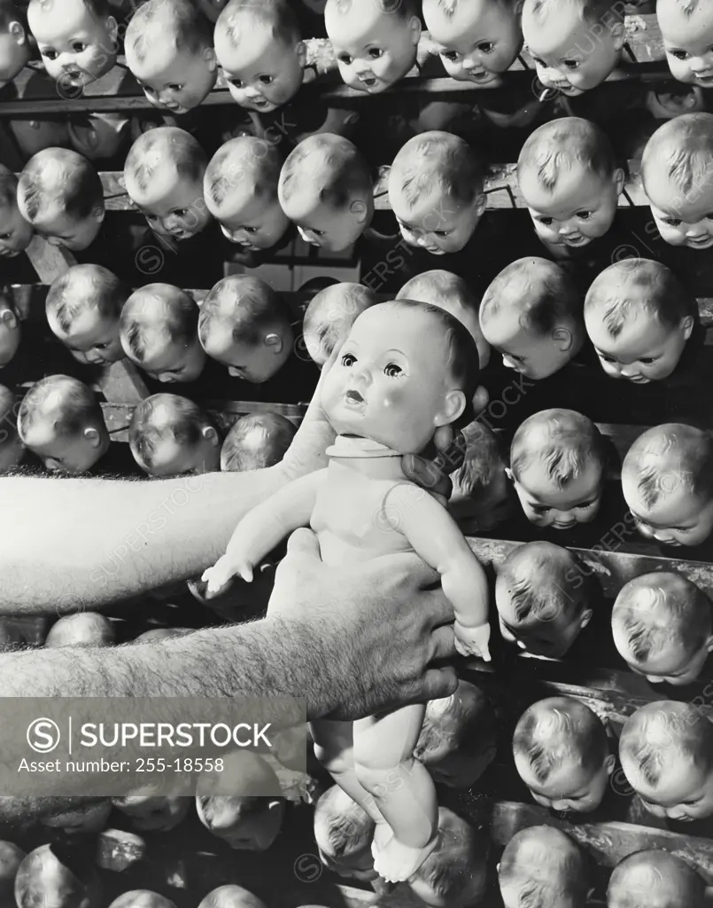 Vintage photograph. Doll manufacturing - placing head of doll on body