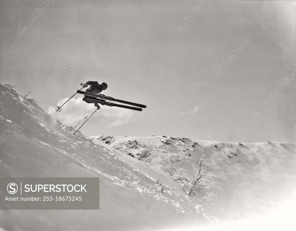 Vintage photograph. Skiing at Tuckerman Ravine on Mt. Washington. Skier jumping in air above the snow.