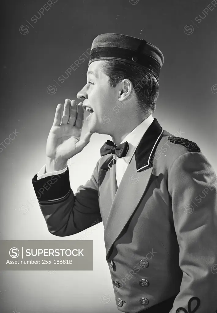 Vintage Photograph. Bellman raising hand to call out while turned to side