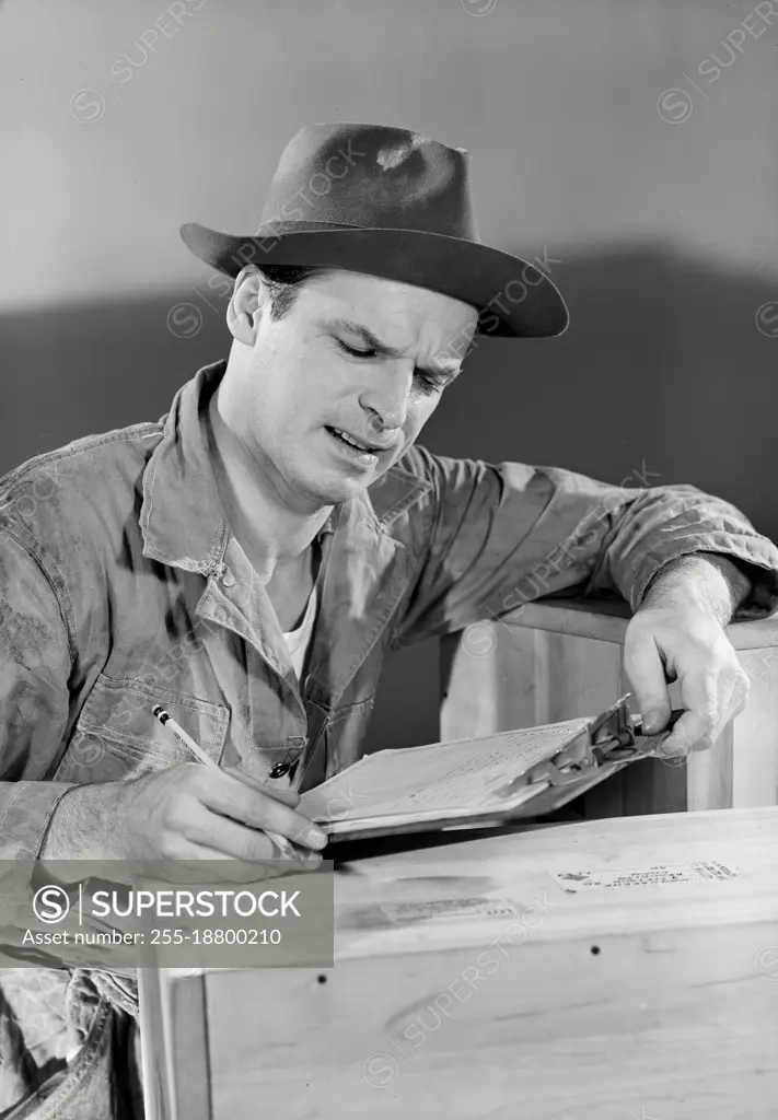 Vintage photograph. Focused working man looking at clipboard