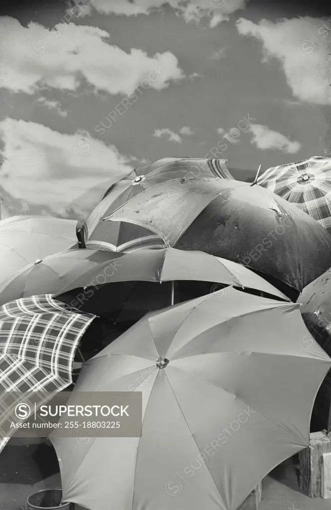 Vintage photograph. Umbrellas in front of sky backdrop