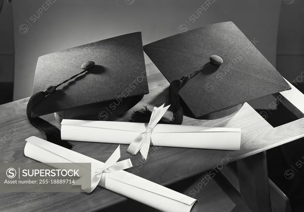 Vintage photograph. 2 Graduation cap with 2 diplomas