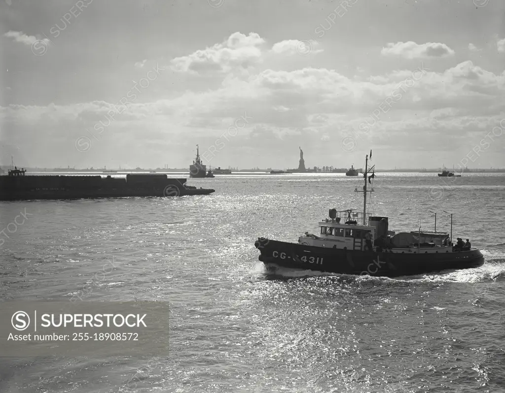 Vintage photograph. Traffic on the waters of New York Harbor with Statue of Liberty in background