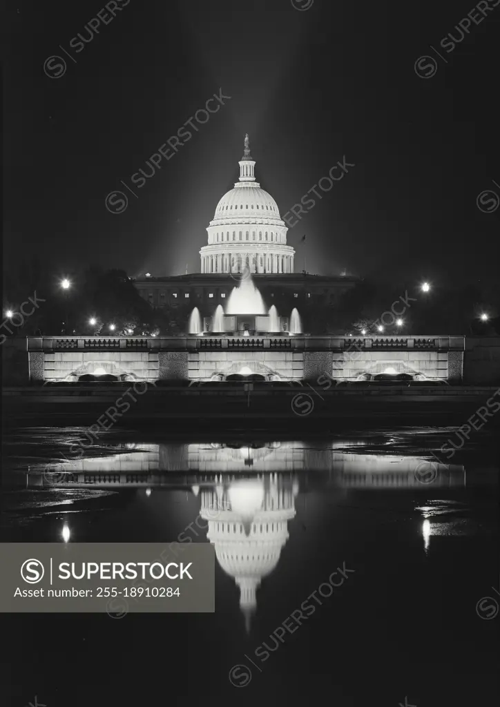 Vintage photograph. Capitol Building lit up at night in front of Capitol Reflecting Pool