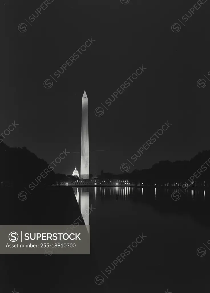 Vintage photograph. Night view of the Washington Monument and Capitol Dome and reflection in pool