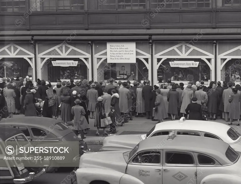 Vintage photograph. Christmas shoppers on sidewalk outside building looking in window, New York City