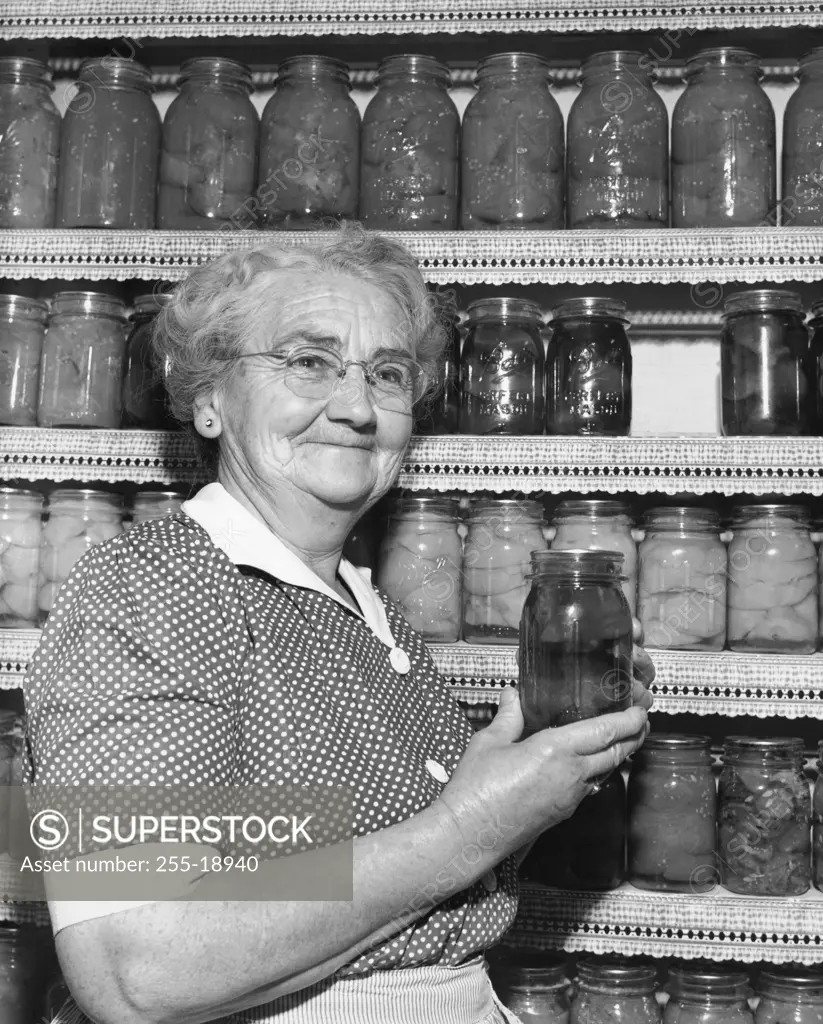 Close-up of a senior woman holding a jar of pickles