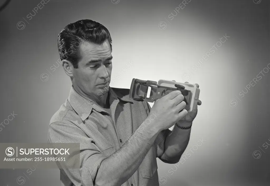 Vintage photograph. man in button shirt holding toy truck