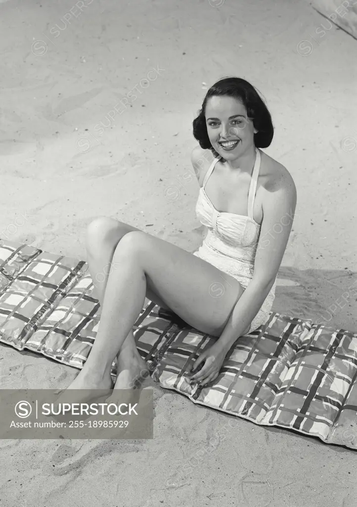 Vintage photograph. Woman in bikini sitting on beach