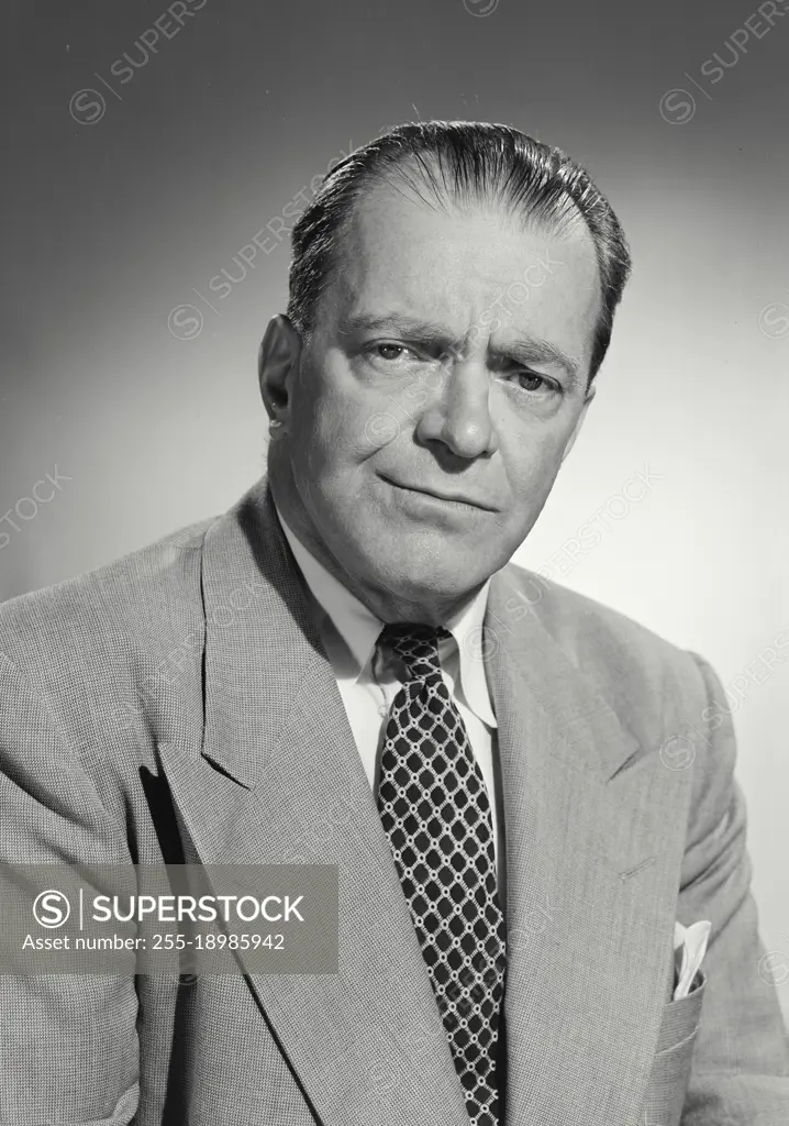 Vintage photograph. Portrait of man in suit and tie smirking