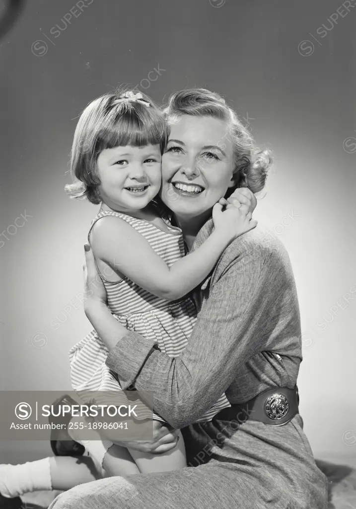 Vintage photograph. Mother and daughter hug each other and smile