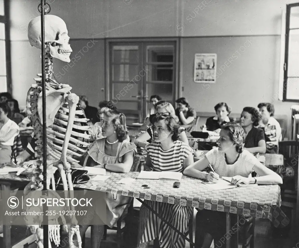 Vintage photograph. Refresher course on anatomy is given to nurses studying physical rehabilitation of crippled children