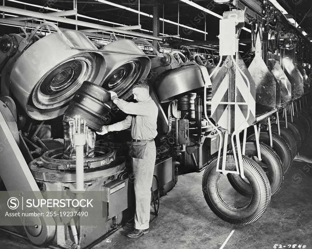 Vintage photograph. The automatic units combining the tire forming and the tire curing operations and increase the output of finished tires at the Des Moines plant of the Firestone Tire and Rubber Company