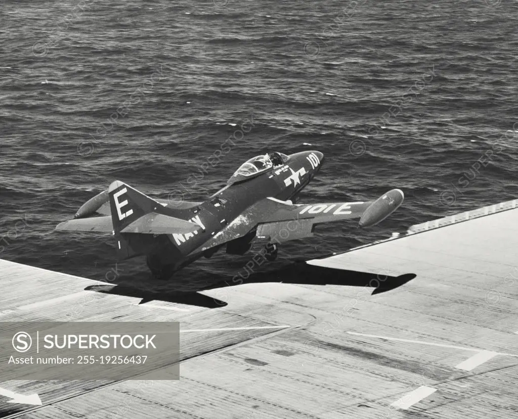 US Navy F9F Blue Angel flies over deck following touch and go off carrier flight deck