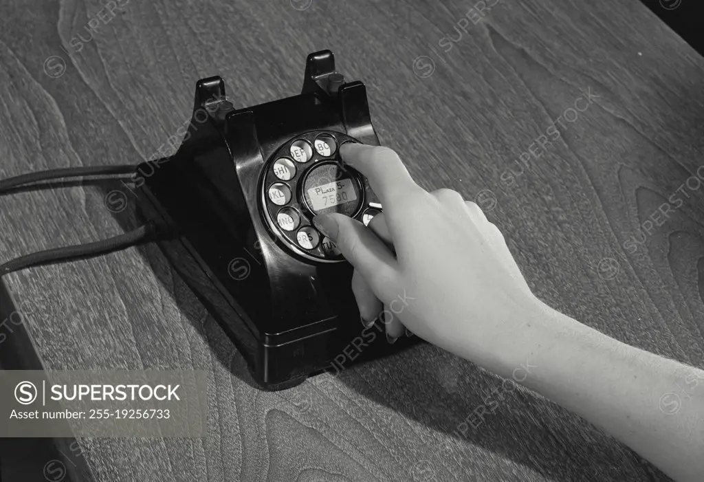 Woman's hands dialing rotary telephone