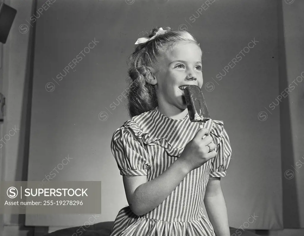 Vintage photograph. Little girl smiling with ice cream pop