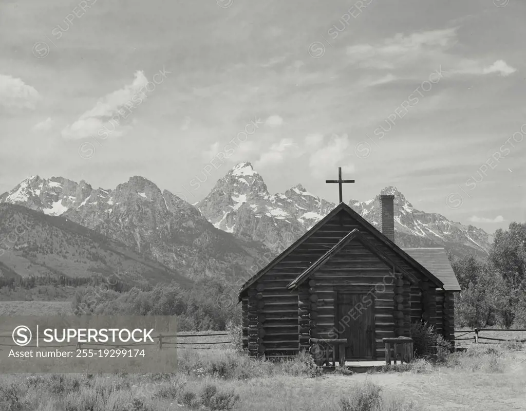 Vintage photograph. Famous Church of the Transfiguration near Moose, Wyoming with Teton Mountains in the background