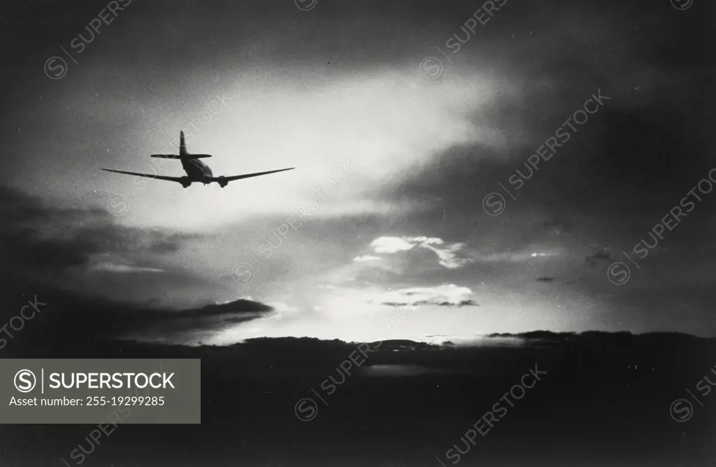 Vintage photograph. Silhouette of Airplane flying in the clouds