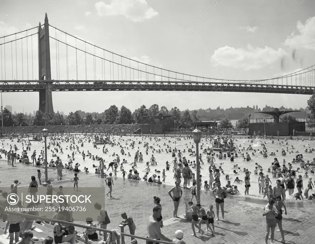 Vintage photograph. Astoria Park Pool. New York City. People playing in public pool with bridge in background