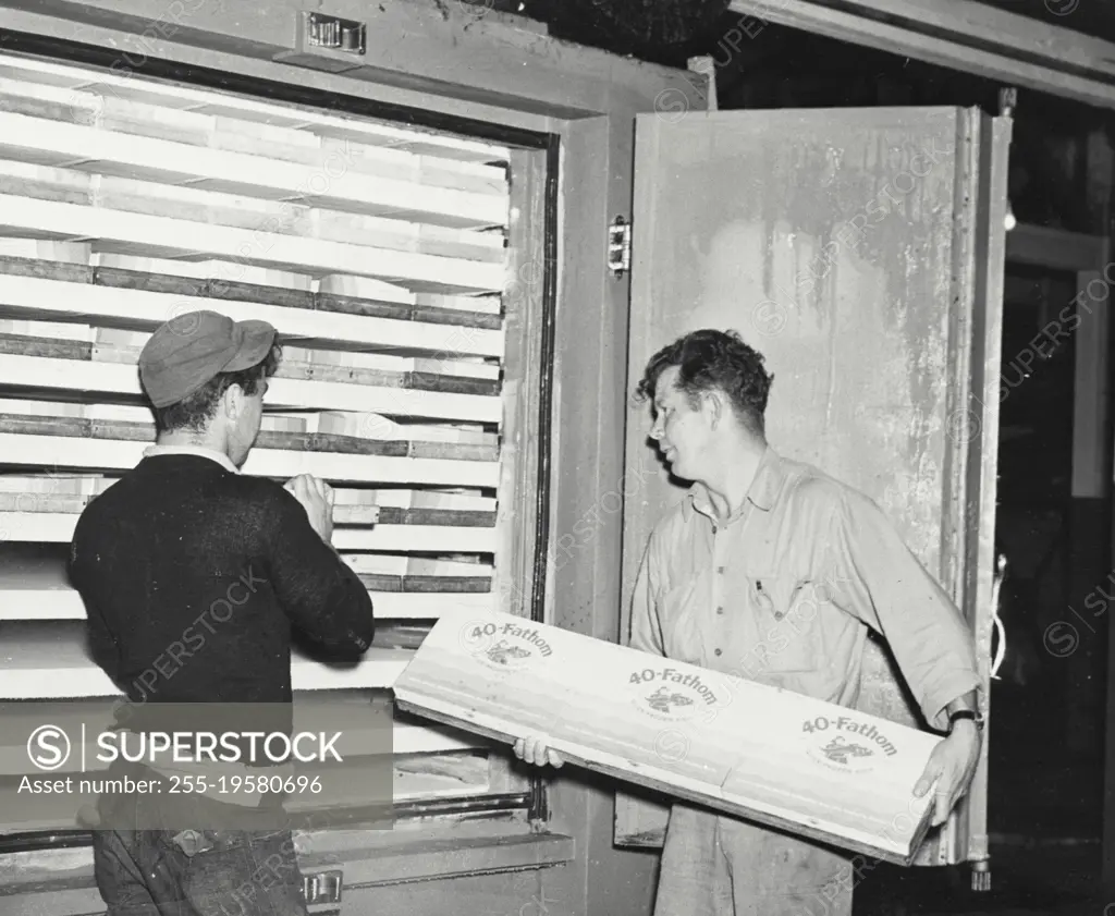 Vintage photograph. Loading freezer with packaged fish