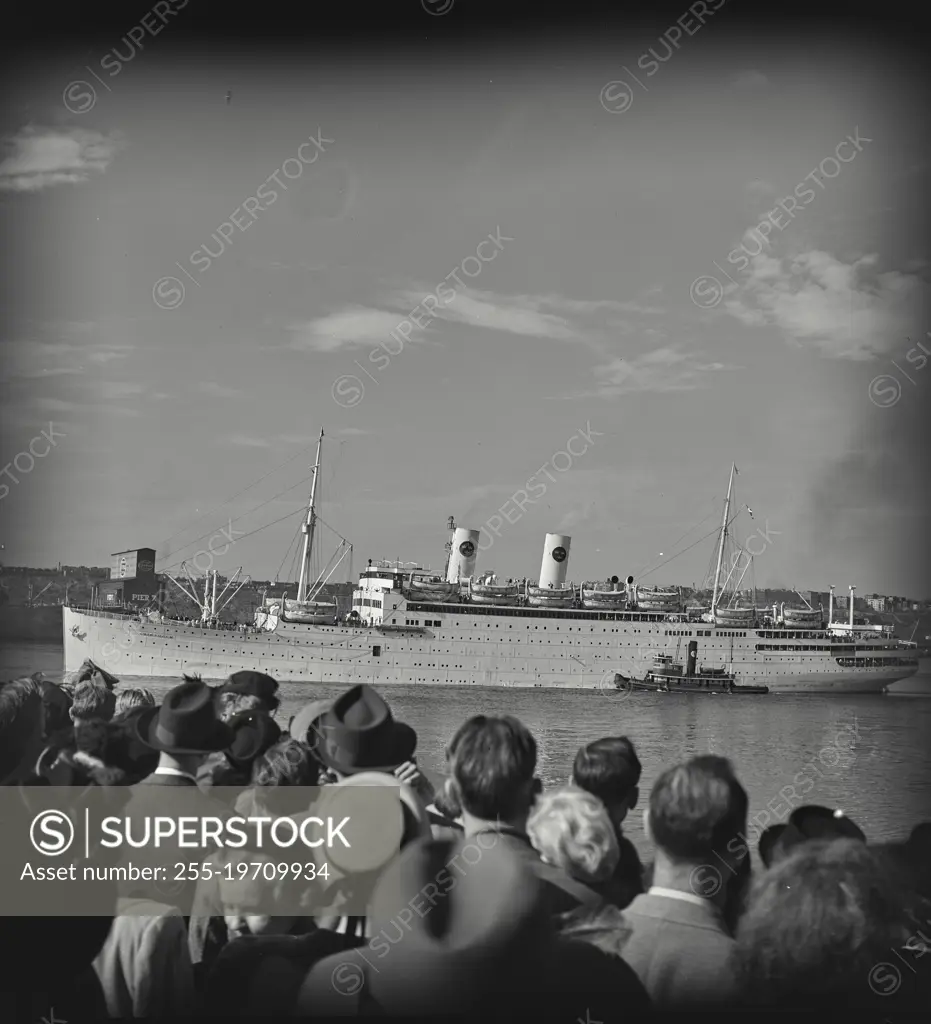 Vintage photograph. Crowd watching SS Gripsholm leave pier