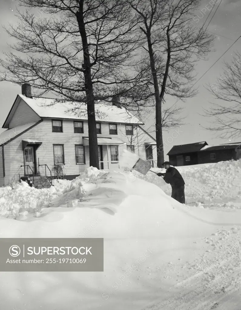 Vintage photograph. Farmer shoveling snow at North Wantagh, Long Island