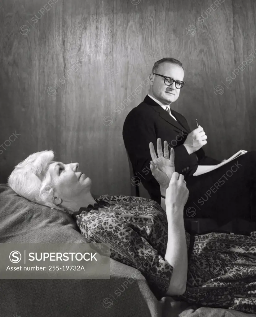 Patient lying in a bed with a male doctor sitting beside her