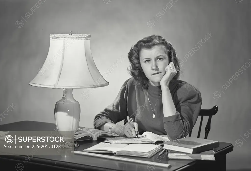 Vintage photograph. Woman at desk resting head on hand thinking