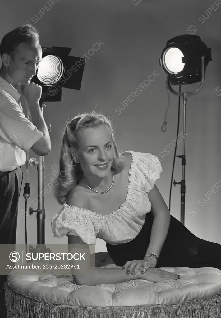 Woman laying on cushion with lights being set behind her