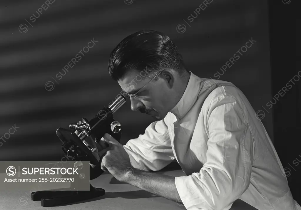 Scientist studying the slide under microscope