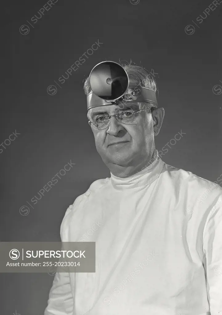 Doctor wearing head mirror looking ahead