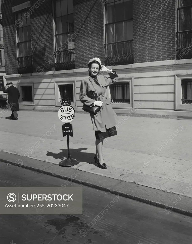 Woman in coat standing at bus stop