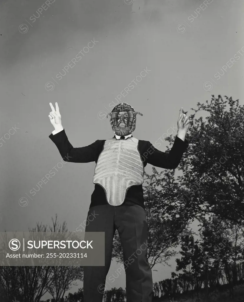 Baseball umpire with facemask making a call