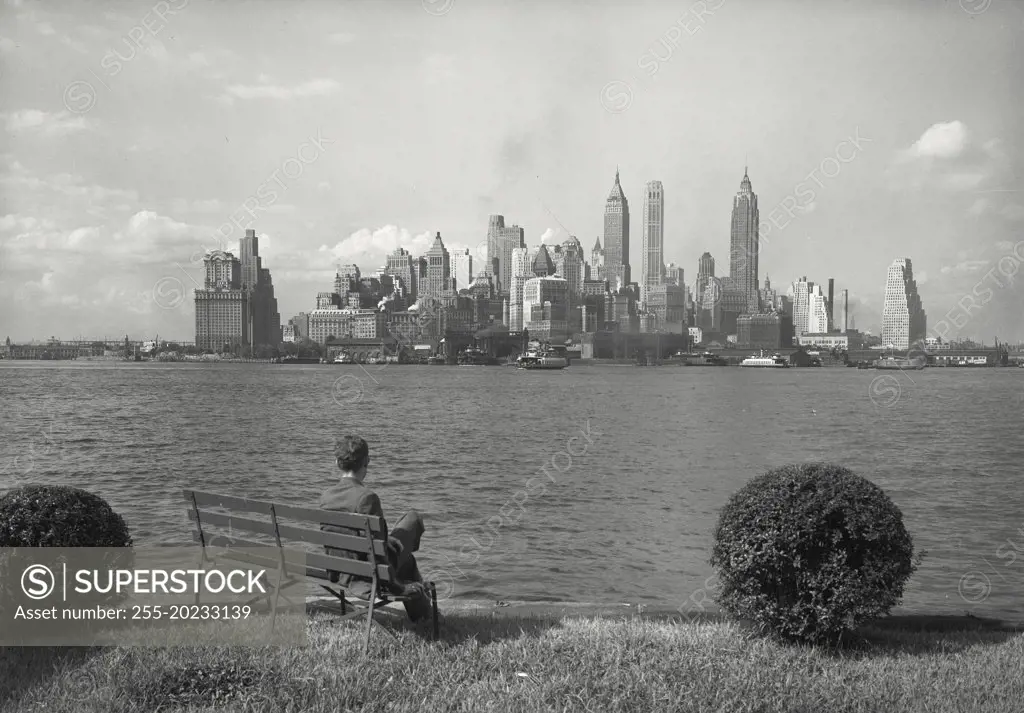 Man sitting on bench admiring Lower Manhattan skyline