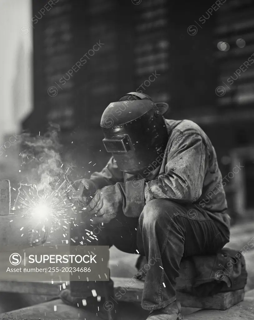 Welder wearing mask doing rod welding