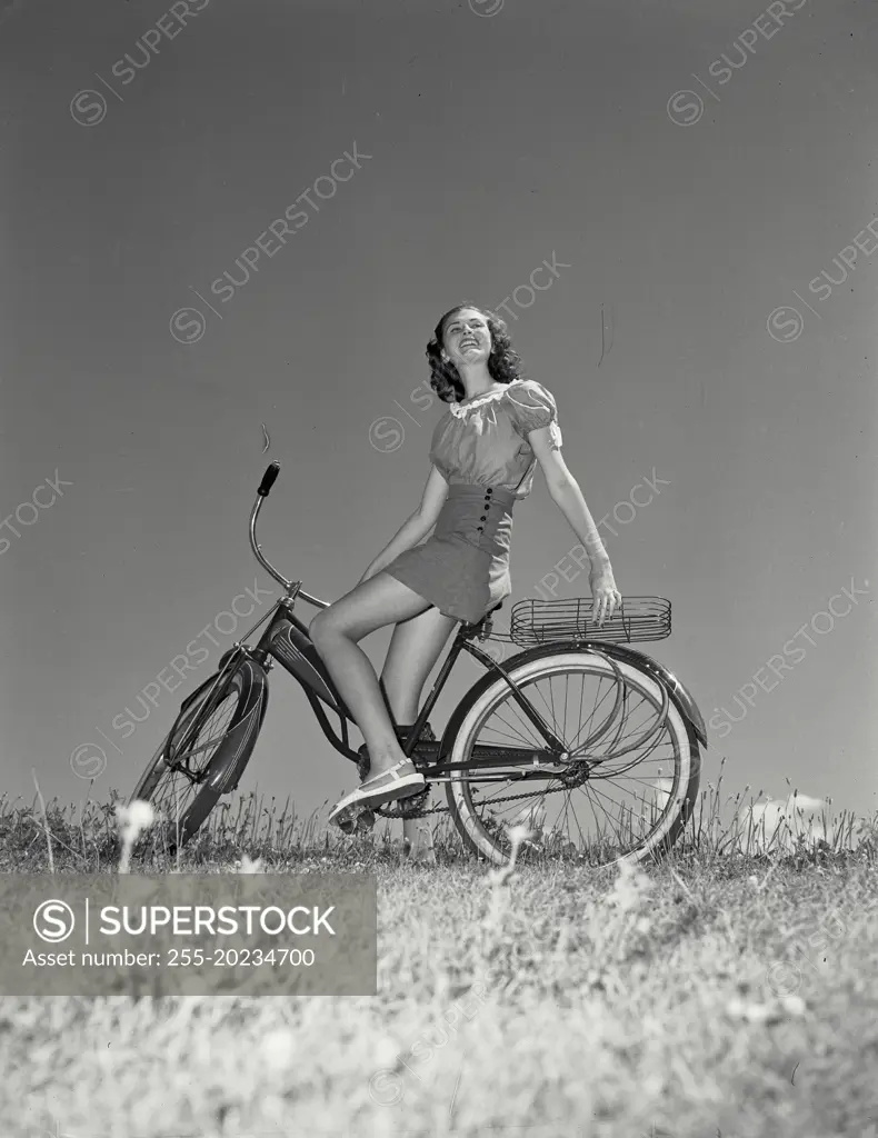 Woman on bicycle leaning back onto the basket