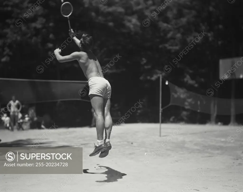 Man jumping during badminton play at Camp Beaverbrook