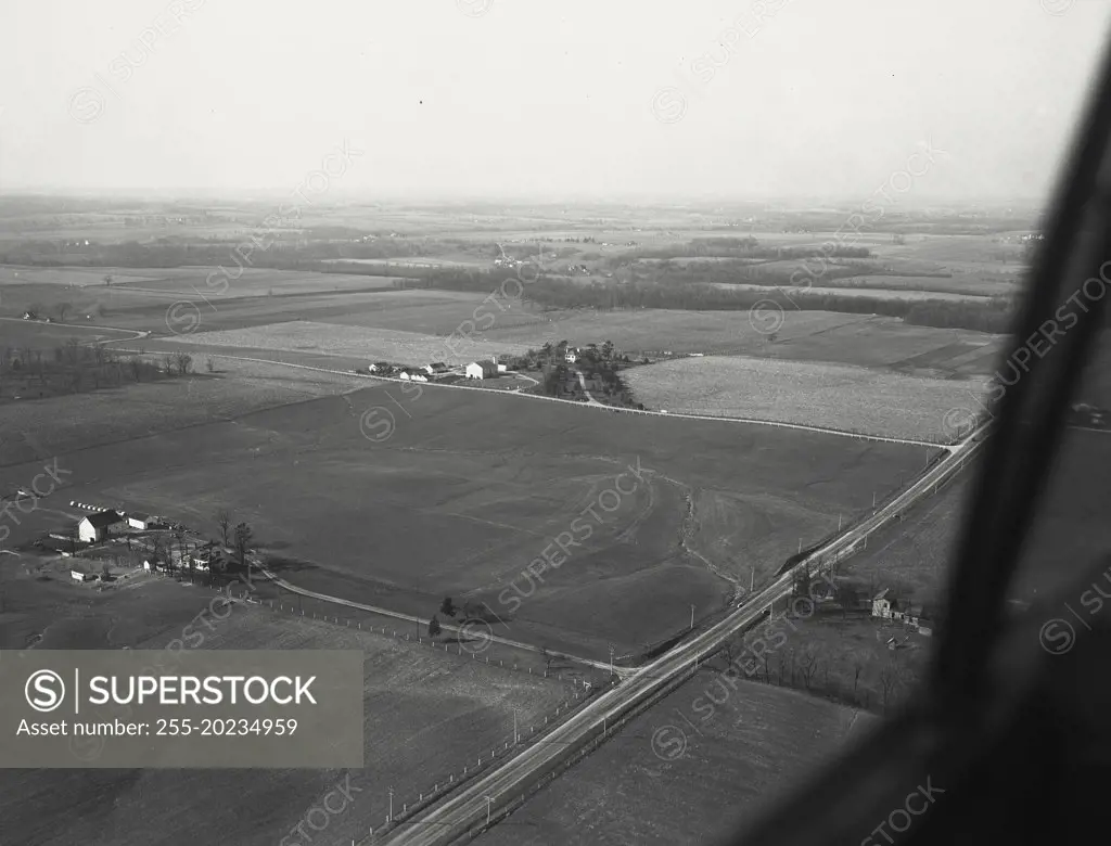 Aerial View of Richmond, Indiana with erosion in field and US 27 in foreground and the residence of FH Coble M.D. in the distance